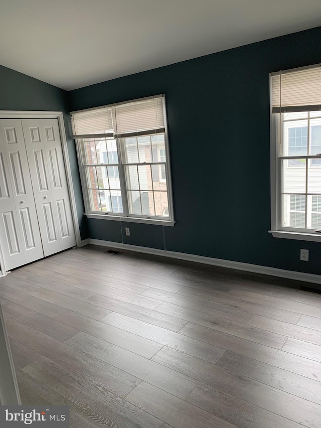 unfurnished bedroom featuring light hardwood / wood-style floors and a closet