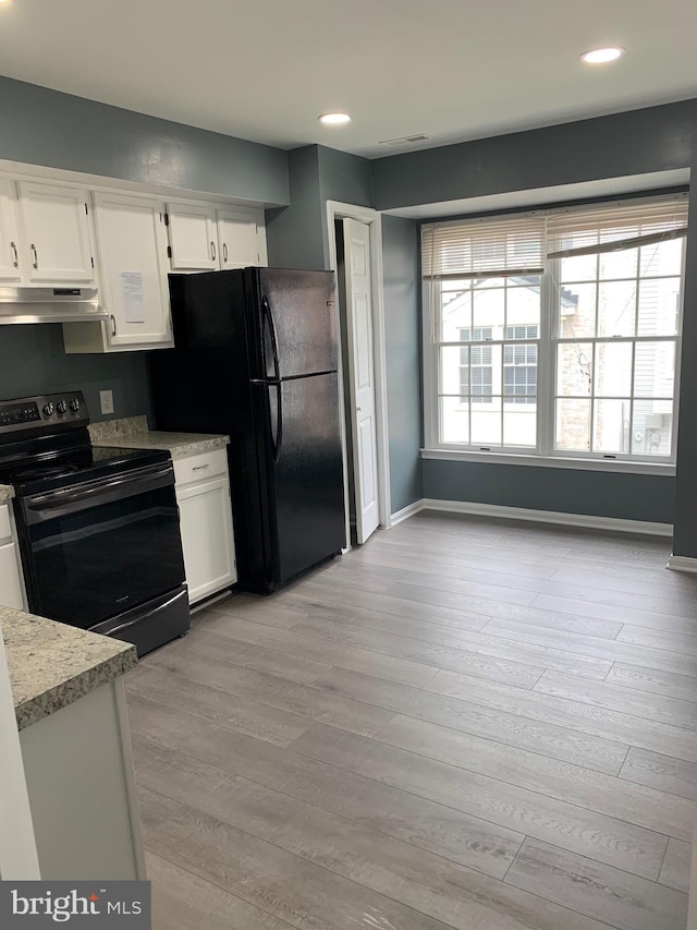 kitchen featuring white cabinets, light hardwood / wood-style floors, and black appliances