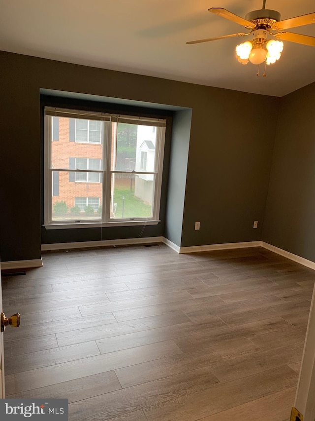 unfurnished room with ceiling fan and light wood-type flooring