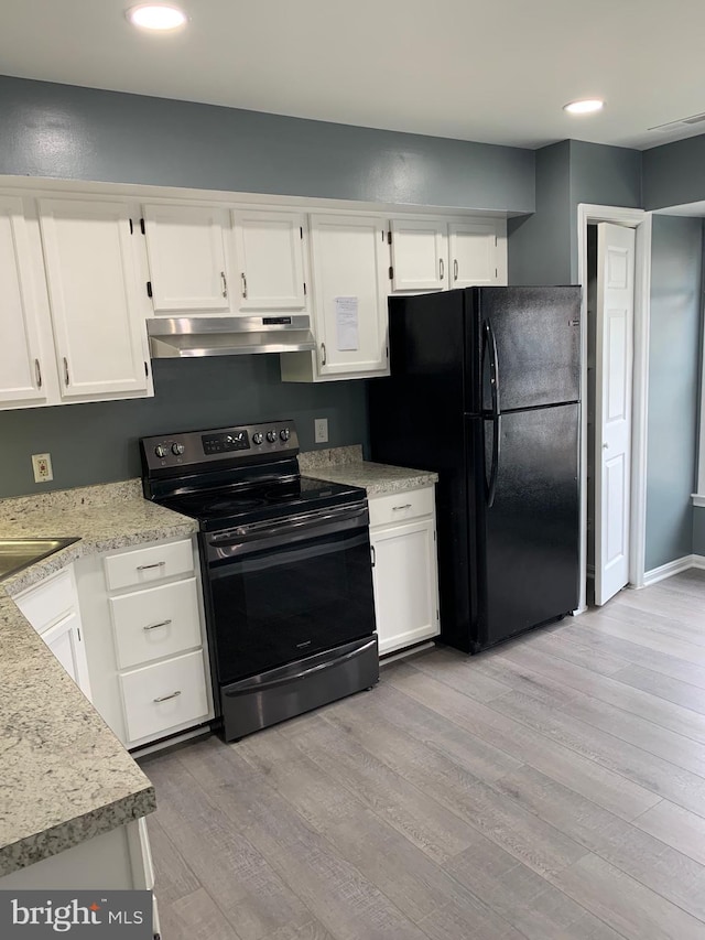 kitchen featuring range with electric stovetop, black refrigerator, sink, white cabinets, and light hardwood / wood-style floors