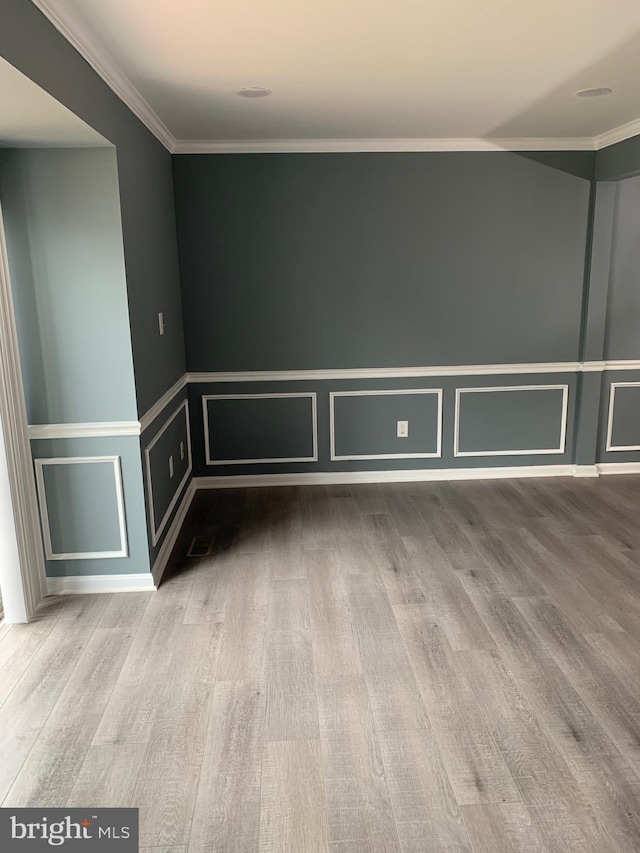 unfurnished room featuring wood-type flooring and ornamental molding