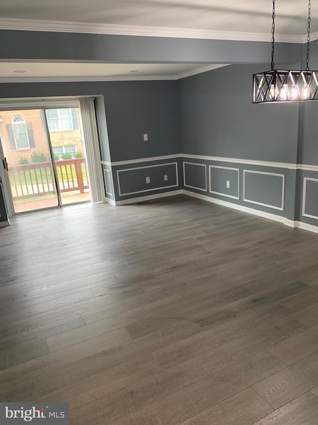 empty room with ornamental molding and wood-type flooring