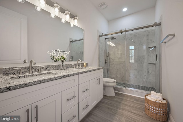 bathroom with vanity, toilet, hardwood / wood-style floors, and a shower with shower door