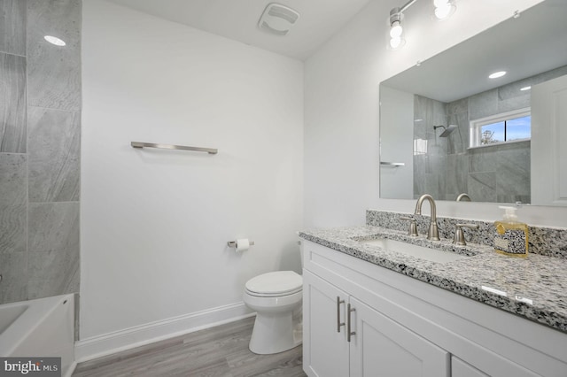 full bathroom with tiled shower / bath, vanity, toilet, and wood-type flooring