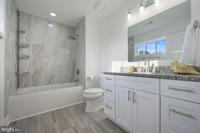 full bathroom with vanity, toilet, tiled shower / bath combo, and wood-type flooring