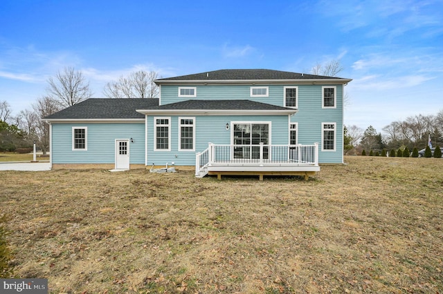 rear view of house featuring a yard and a deck