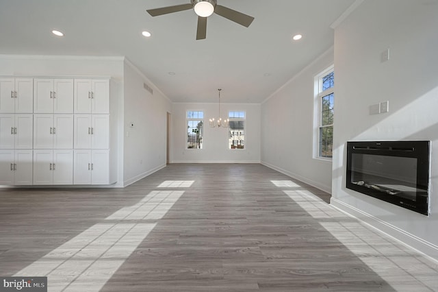 unfurnished living room featuring ceiling fan with notable chandelier, ornamental molding, and light hardwood / wood-style floors