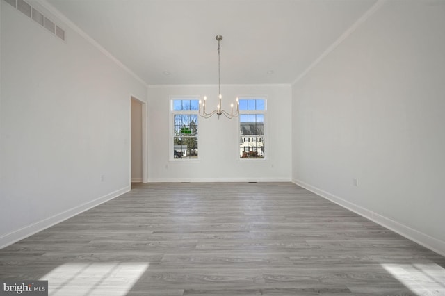 unfurnished dining area with crown molding, a chandelier, and light hardwood / wood-style flooring