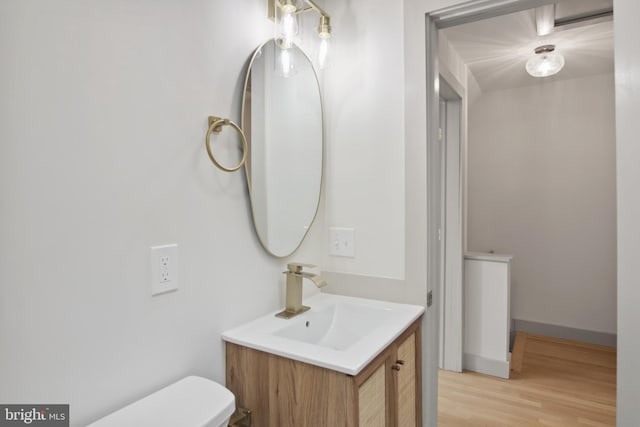 bathroom with vanity, hardwood / wood-style floors, and toilet