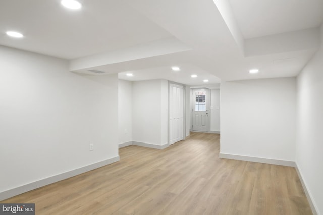 basement with light hardwood / wood-style flooring