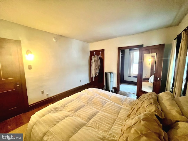 bedroom featuring radiator, wood-type flooring, and a closet