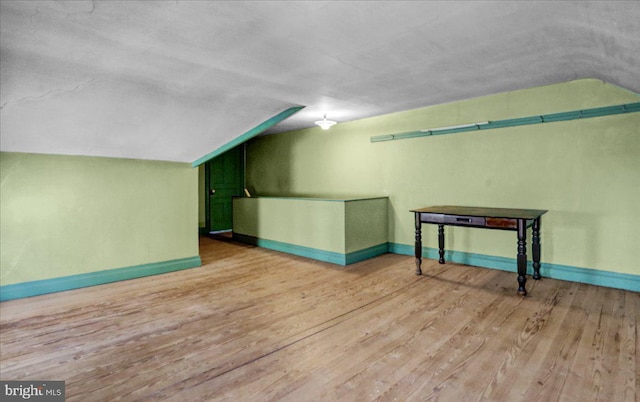 additional living space with lofted ceiling and light hardwood / wood-style floors