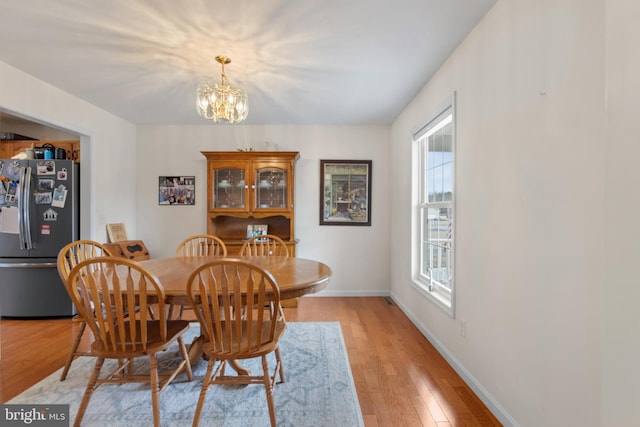 dining space featuring an inviting chandelier and light hardwood / wood-style floors