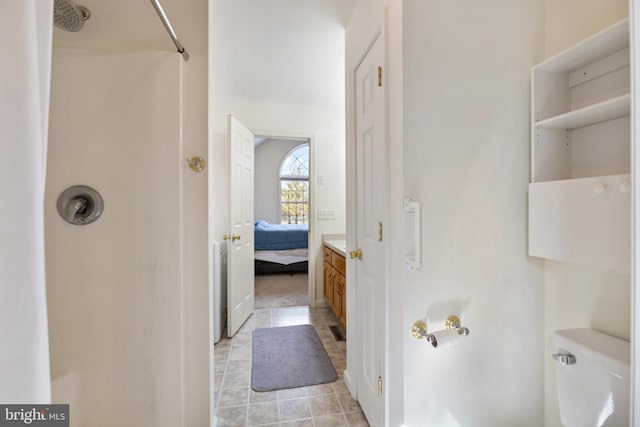 bathroom with a shower, tile patterned floors, and toilet