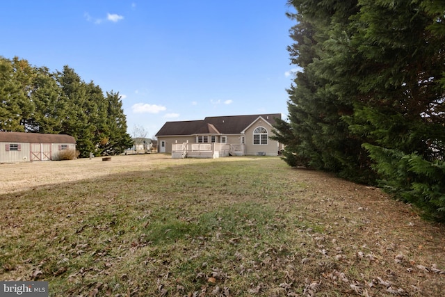 view of front of home featuring a deck, a front lawn, and a shed