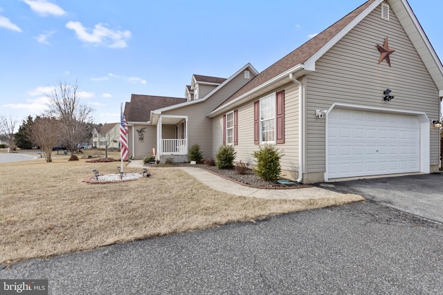 view of front facade with a garage, a front lawn, and a porch