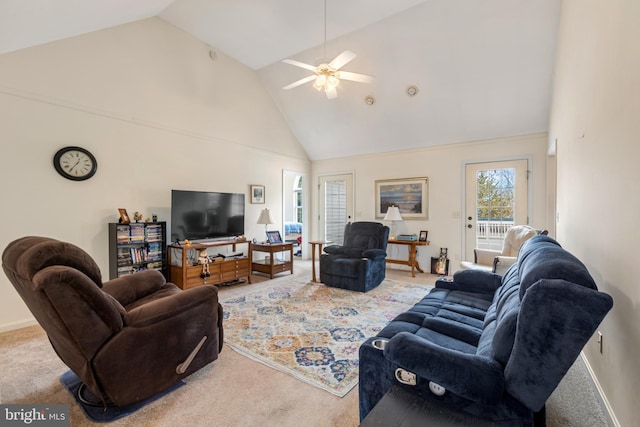 carpeted living room with ceiling fan and high vaulted ceiling