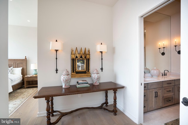 corridor with sink and light hardwood / wood-style floors