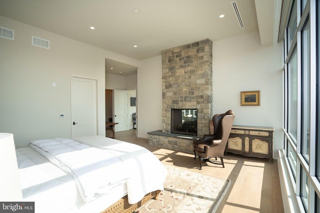 bedroom with a fireplace and light hardwood / wood-style floors