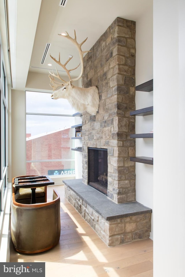 unfurnished living room with a stone fireplace and hardwood / wood-style flooring