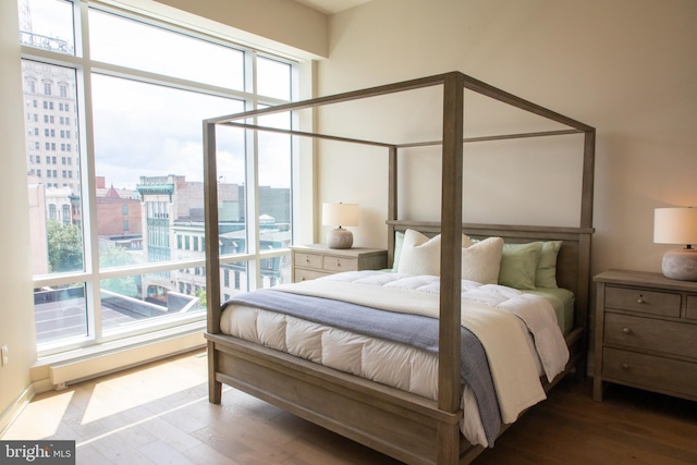 bedroom with hardwood / wood-style flooring and baseboard heating