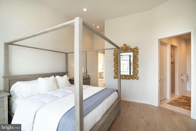 bedroom featuring ensuite bath and light hardwood / wood-style flooring