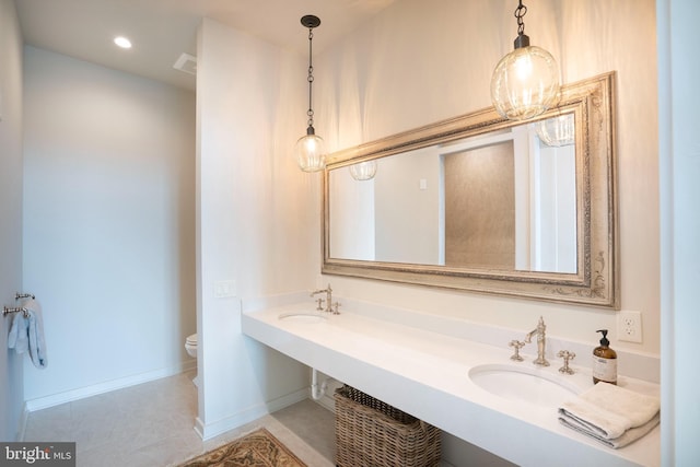 bathroom with double sink and toilet