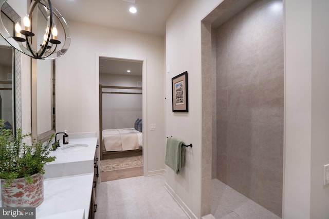 bathroom with an inviting chandelier, vanity, and tile patterned flooring