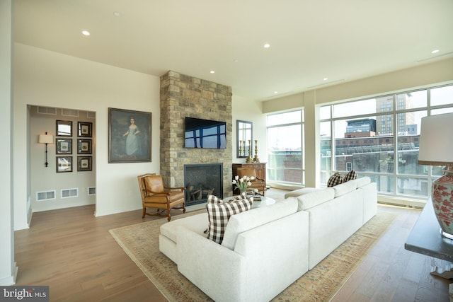 living room with a fireplace and light wood-type flooring