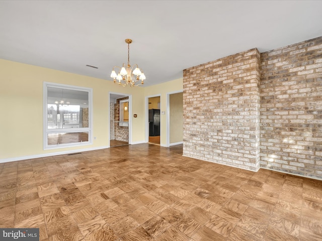 interior space with brick wall and a chandelier