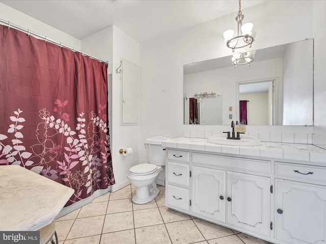 bathroom featuring tile patterned flooring, vanity, a chandelier, and toilet