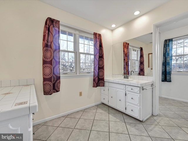 bathroom with tile patterned floors, a healthy amount of sunlight, and vanity