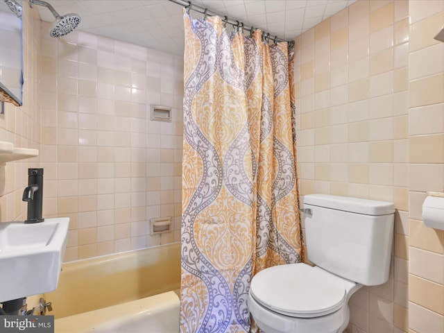 full bathroom featuring sink, tile walls, shower / bath combo with shower curtain, and toilet