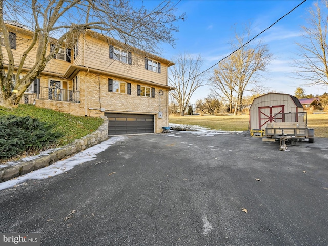 view of side of property with a garage and a storage unit