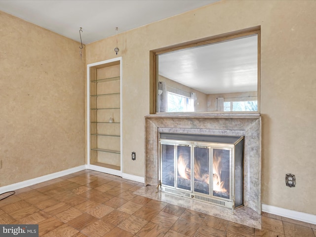 unfurnished living room featuring a premium fireplace