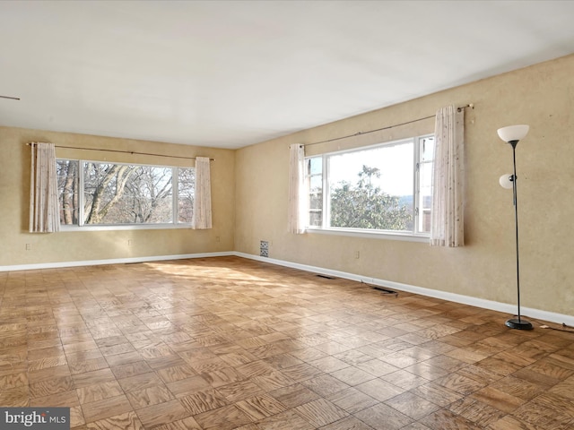 unfurnished room featuring plenty of natural light