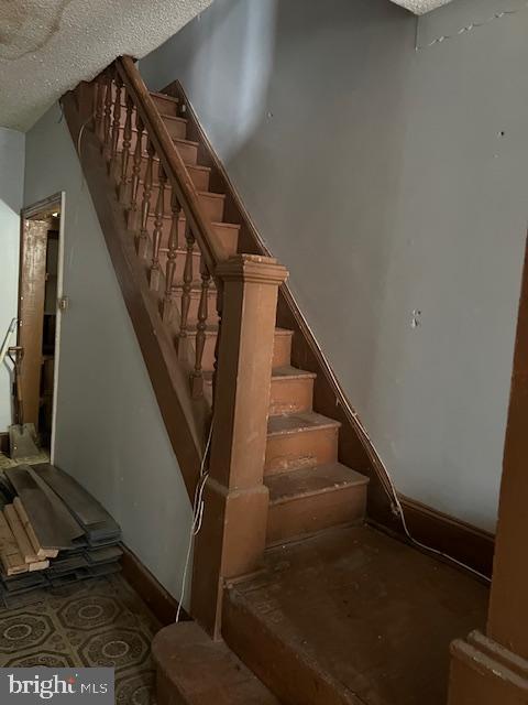 staircase with a textured ceiling