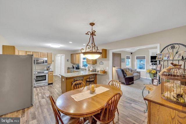 dining room featuring sink and light hardwood / wood-style floors