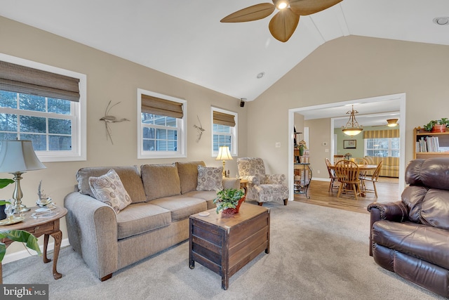 carpeted living room with ceiling fan, vaulted ceiling, and a healthy amount of sunlight