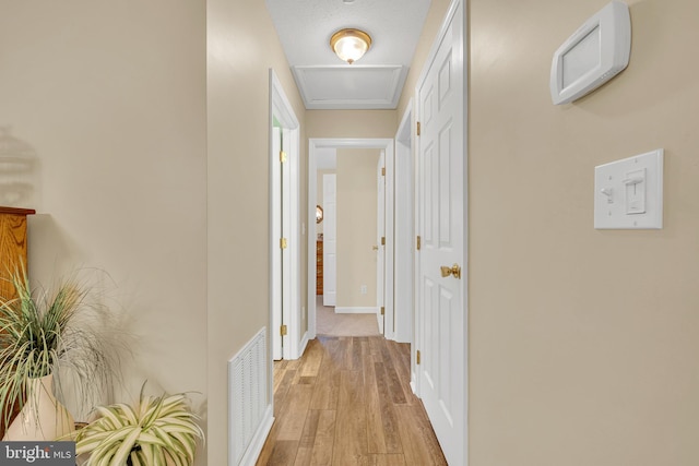 corridor with light hardwood / wood-style floors