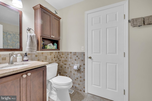 bathroom featuring vanity, tile walls, tile patterned floors, and toilet