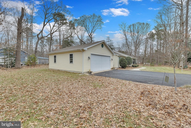 view of side of property with a garage and a lawn