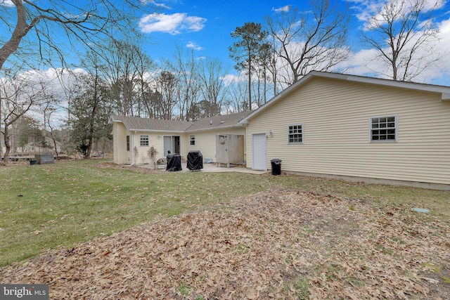 rear view of house featuring a patio area and a lawn