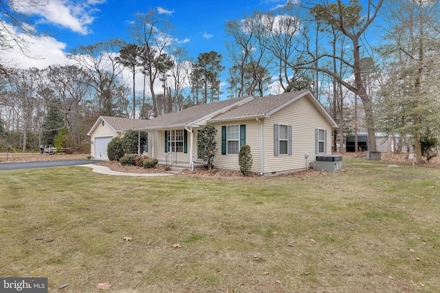 ranch-style home featuring a garage, central AC unit, and a front lawn