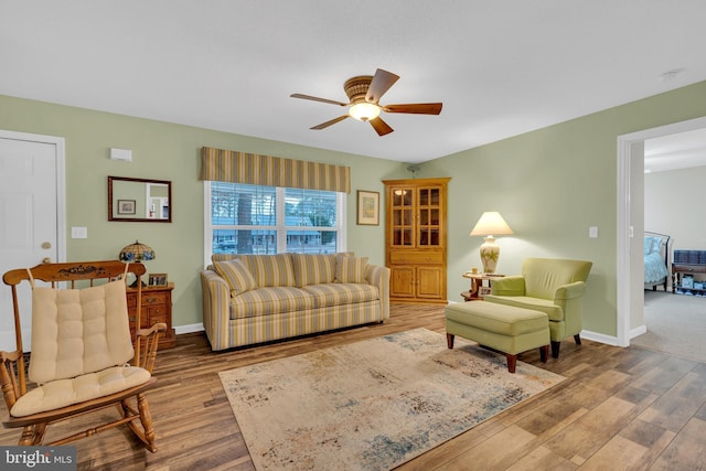 living room featuring ceiling fan and light hardwood / wood-style flooring