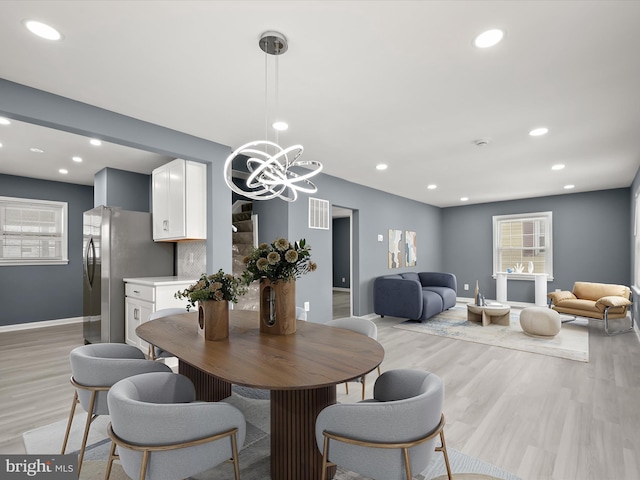 dining area with light hardwood / wood-style flooring and a chandelier