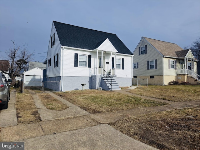 view of front of home featuring a garage, an outdoor structure, and a front lawn