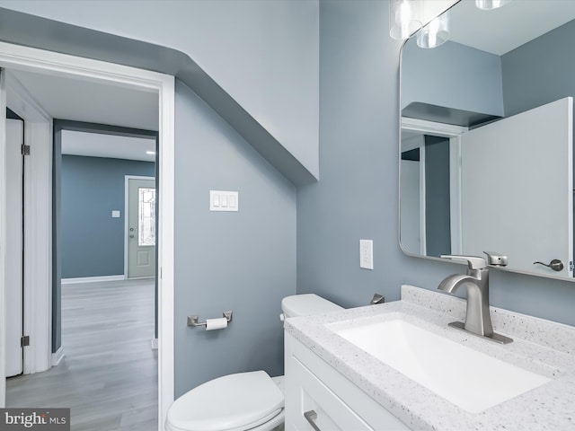 bathroom featuring vanity, hardwood / wood-style floors, and toilet