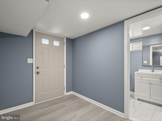 foyer entrance featuring sink and light hardwood / wood-style flooring