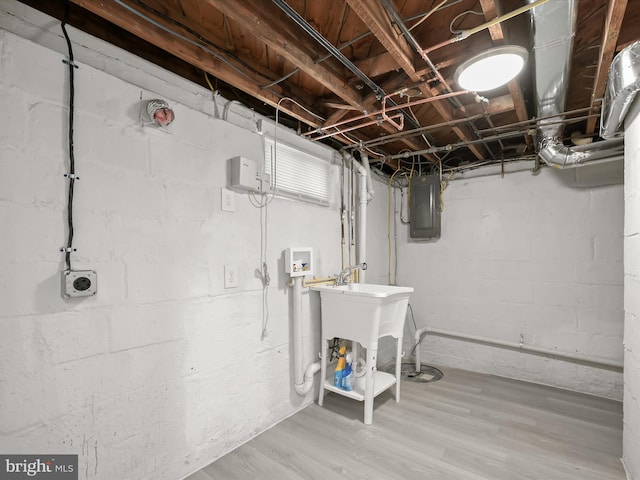 basement with electric panel and hardwood / wood-style floors